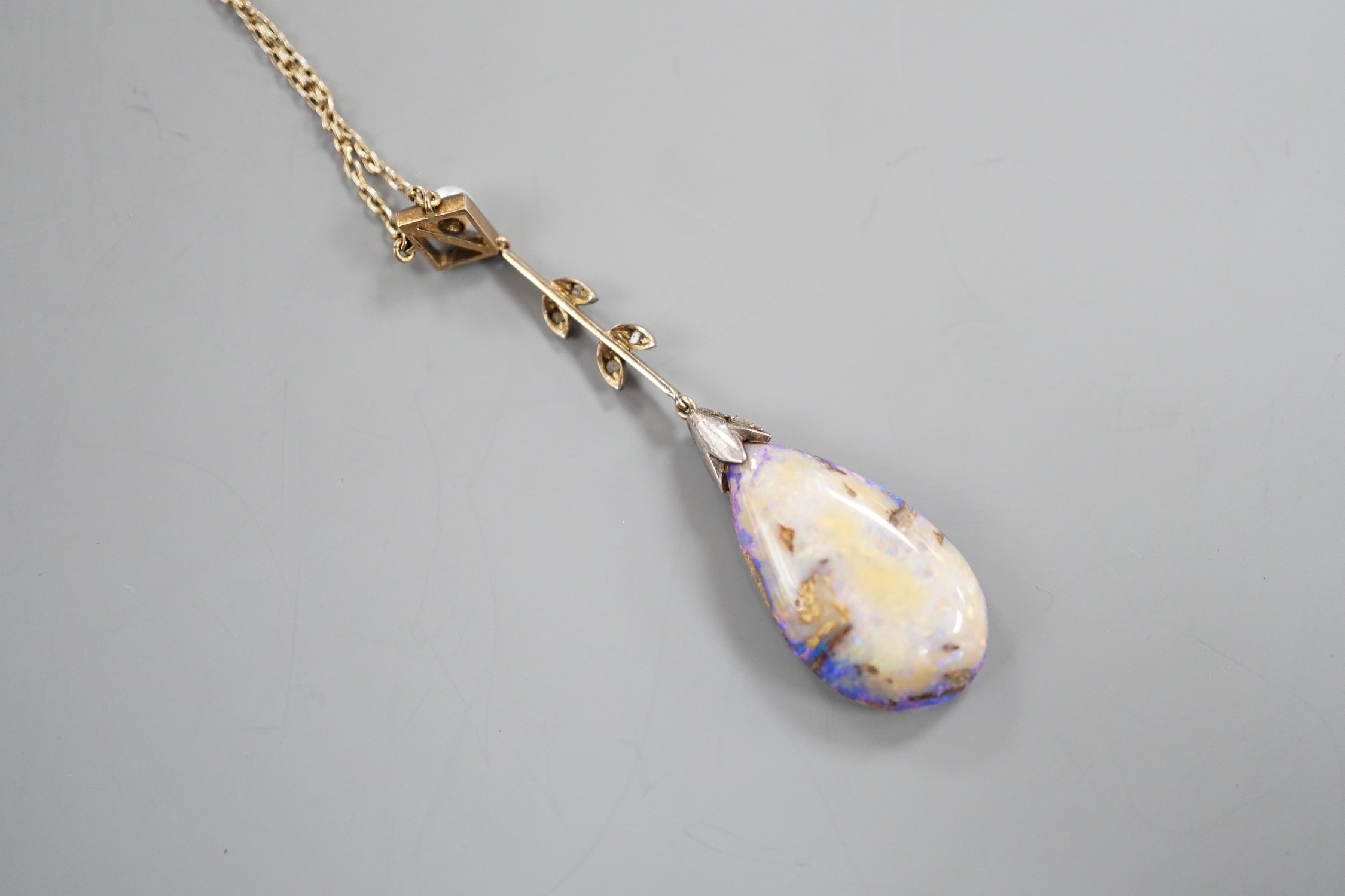 An early 20th century yellow and white metal, pear shaped black opal, rose cut diamond and seed pearl set drop pendant necklace, pendant overall 57mm, chain stamped 9ct, 37cm, gross weight 5.9 grams.
